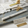 A sleek cylindrical calacatta gold marble rolling pin with polished surface and subtle veining for baking use