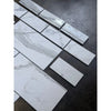 Calacatta Gold white marble-effect 4 3/4x12 baseboard trim with gray veining, some wrapped in plastic