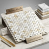 Calacatta gold 5/8x1 1/4 mini-herringbone mosaic marble tile featuring white and beige veined polished pieces on a stone tray