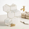 White hexagonal calacatta gold italian marble tiles with subtle gray veining in a polished or honed modern mosaic pattern
