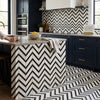 Black and white chevron-patterned calacatta gold mosaic marble tile kitchen island with polished modern design