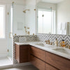 Modern double-sink vanity with calacatta gold chevron large blue-gray mosaic marble tile backsplash and gold fixtures