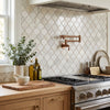 Copper-colored wall-mounted faucet with a sleek modern design paired with Calacatta gold lantern mosaic marble tile