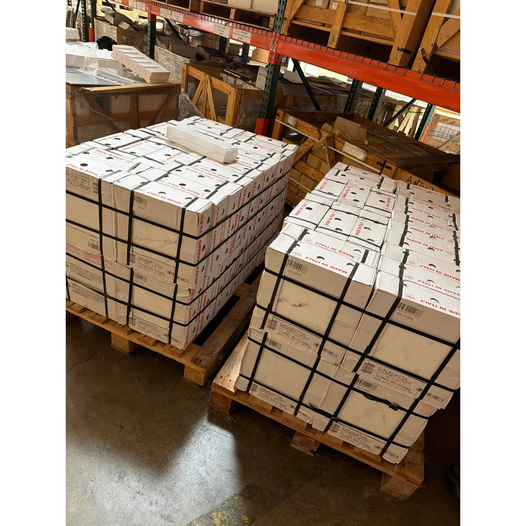 Stacks of white boxes labeled with Calacatta Gold Marble 12x12 polished or honed barcodes