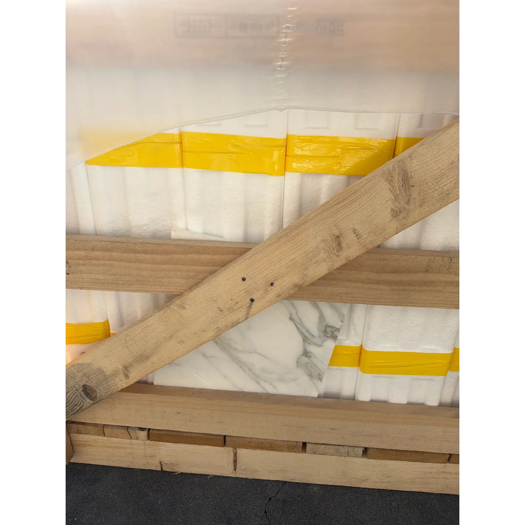 Back of Calacatta Gold Marble 12x12 on wooden pallet with weathered planks