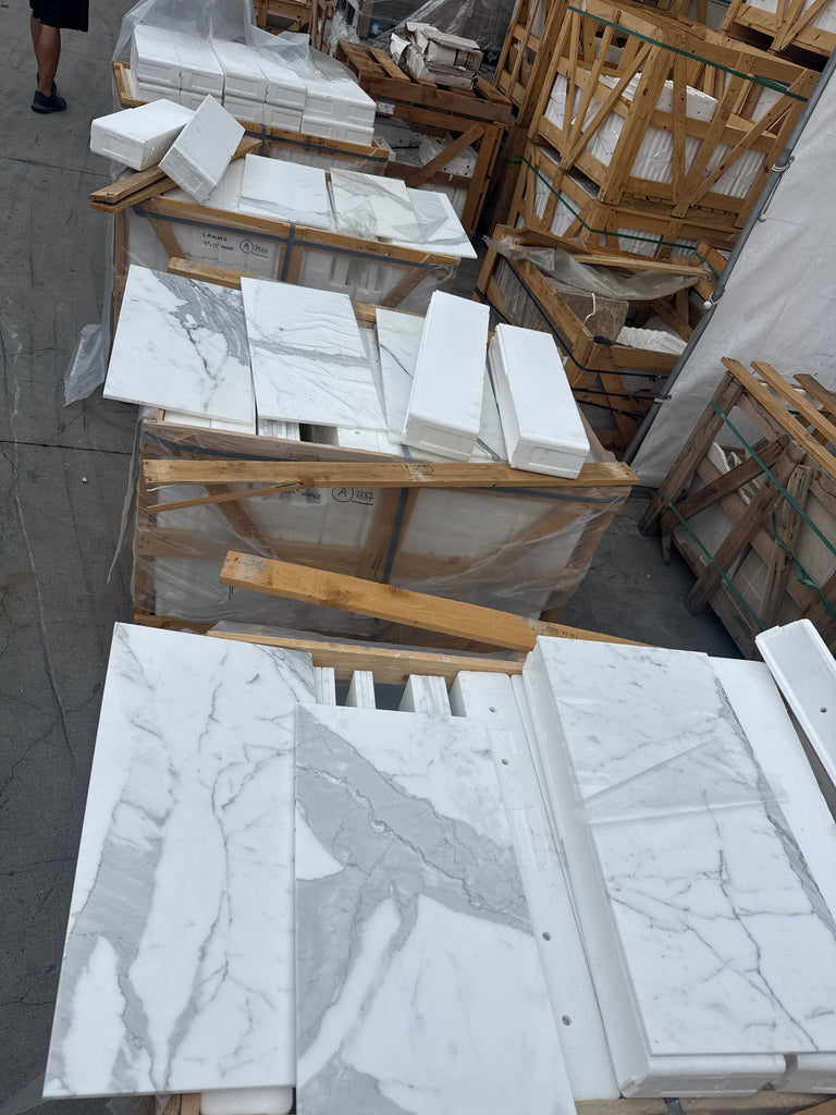Stacked Calacatta Gold Marble 12x24 tiles with white background and grey veining