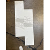 White and gray marble-look tile samples on dark floor for Calacatta Gold Marble 12X24 product