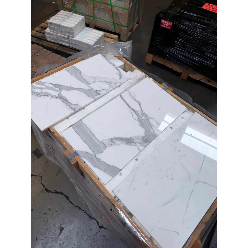 White and gray Calacatta Gold Marble 12x24 tiles with distinct veining patterns