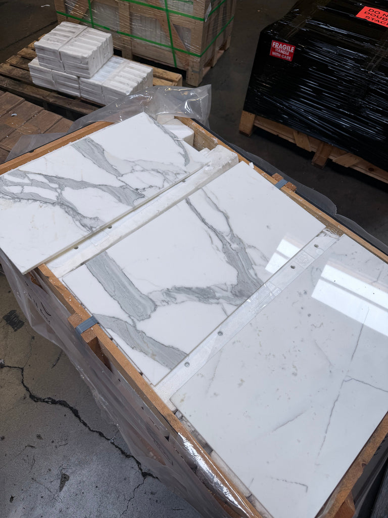 White and gray Calacatta Gold Marble 12x24 tiles with distinct veining patterns