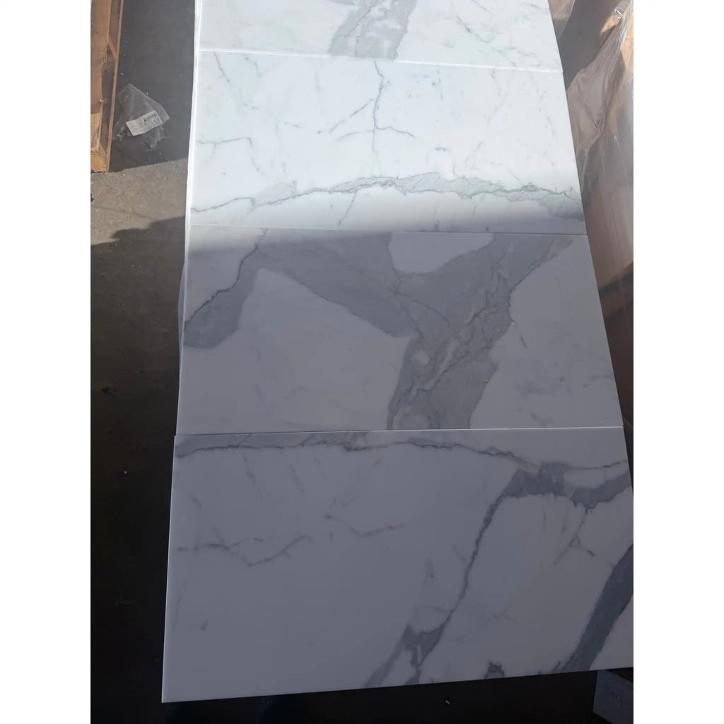 White and grey marble-patterned ceramic tiles from Calacatta Gold Marble 12X24 collection