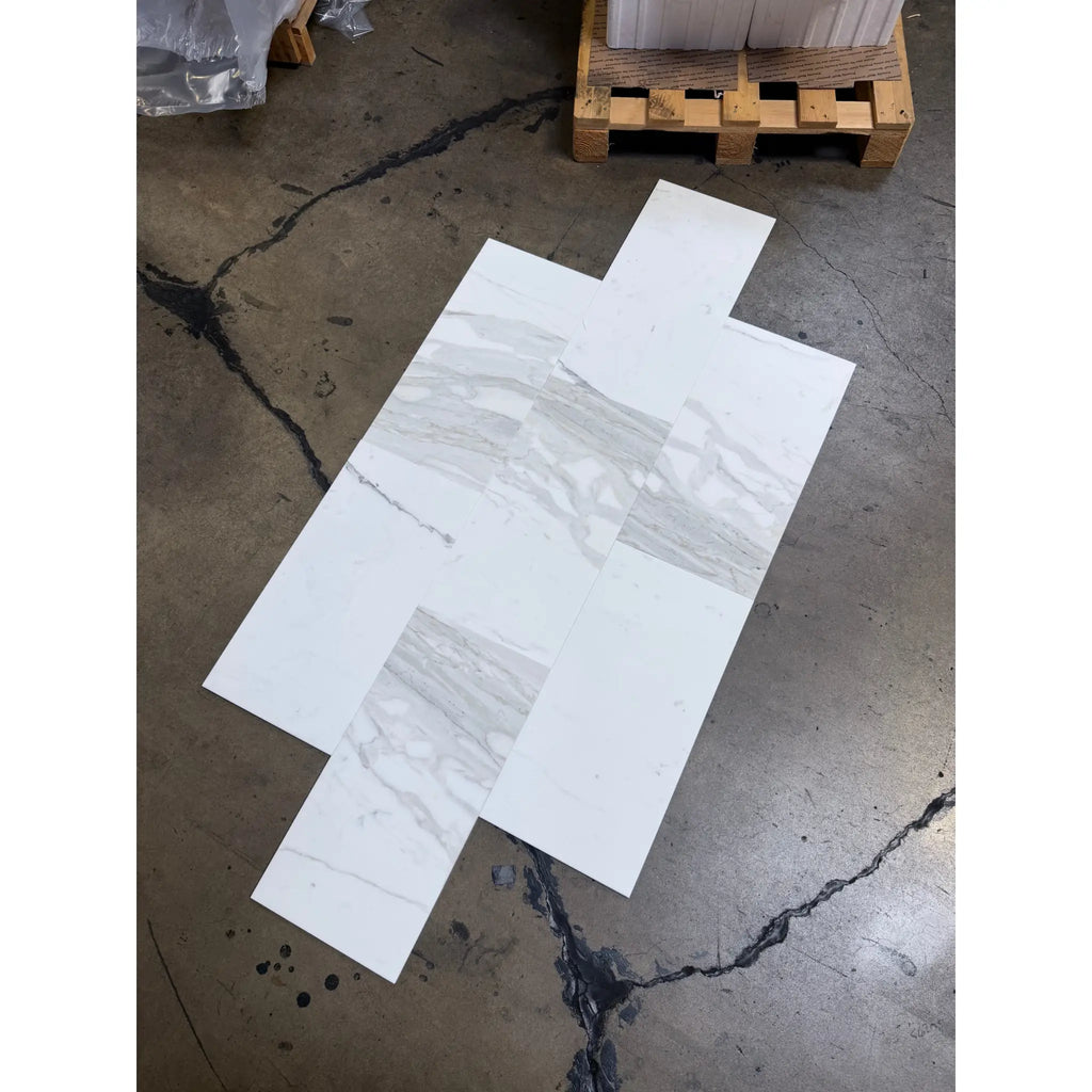 White marble-look tiles with gray veining from Calacatta Gold Marble 12X24 collection
