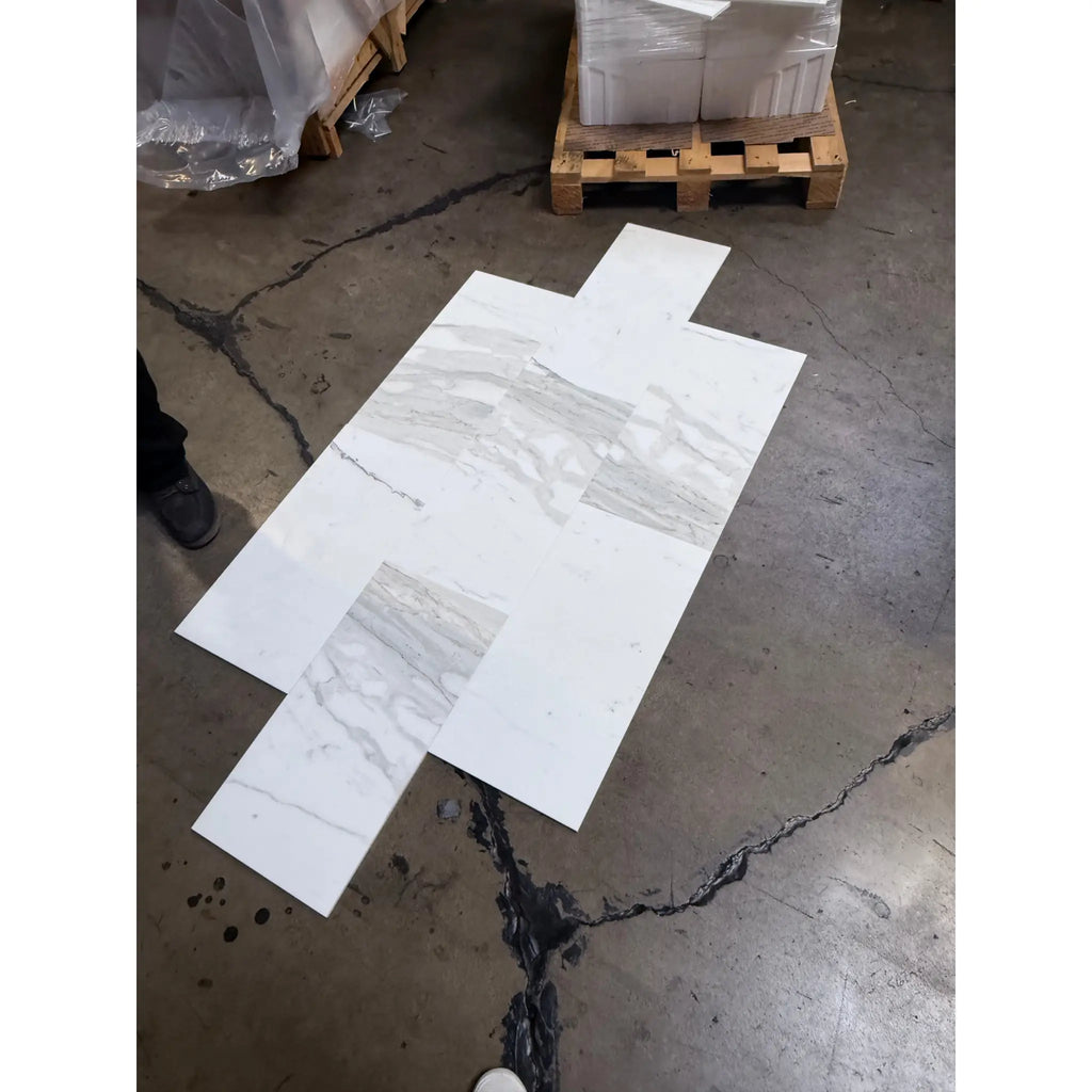 White marble-look tiles with gray veining from Calacatta Gold Marble 12x24 collection