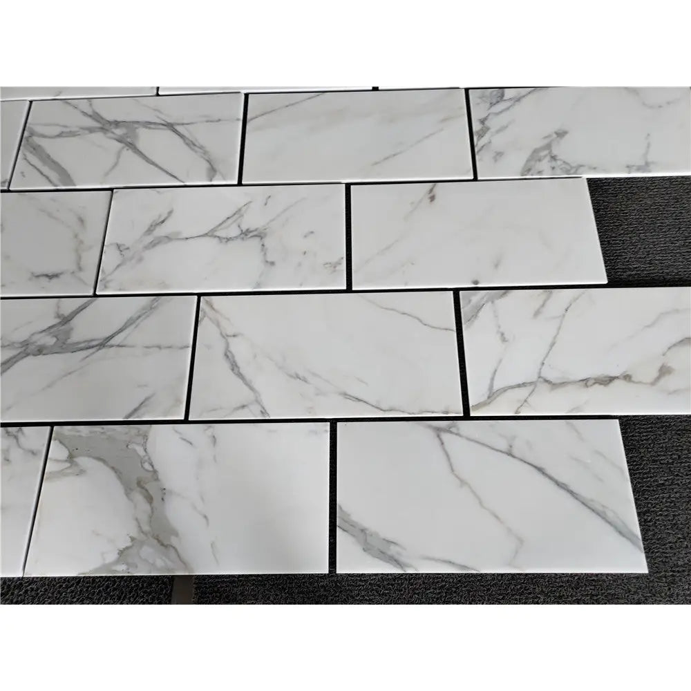 White marble-patterned rectangular tiles from Calacatta Gold Marble 12X24 collection