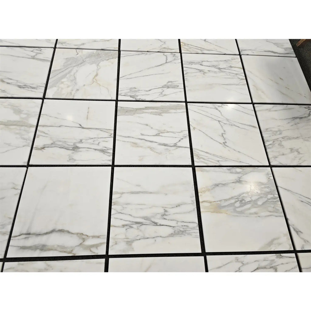 White marble Calacatta Gold 18x18 tiles with elegant gray veining arranged in a polished or honed grid pattern