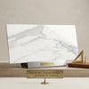 Calacatta gold marble 18x36 polished slab of white carrara marble with elegant gray veining on a sleek metallic stand