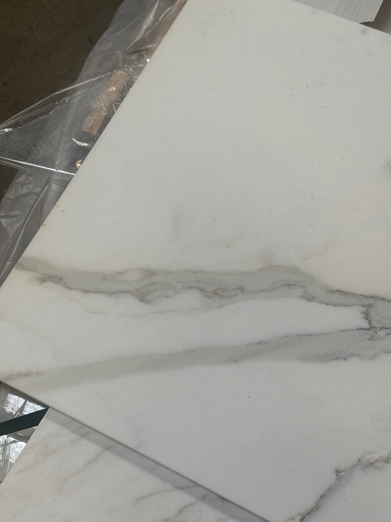 White marble tile with gray veining from Calacatta Gold Marble 18x36 collection