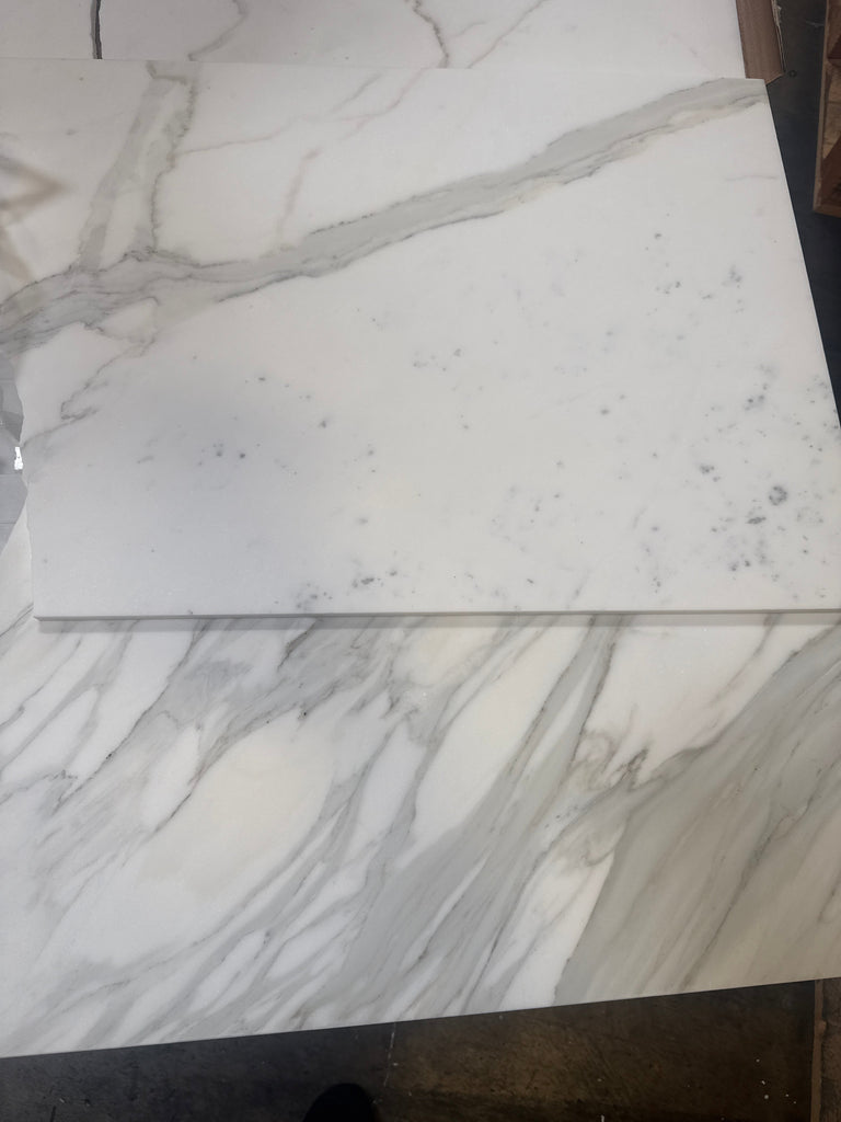 White marble tiles with grey veining from Calacatta Gold Marble 18X36 collection