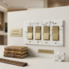 Calacatta gold marble 4 gang rocker switch wall plate featuring gold-toned toggle switches on white marble