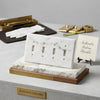 Calacatta gold marble 4 gang toggle switch wall plate in white marble with gray veining on wood and gold trim base