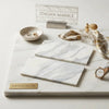 Calacatta gold marble 6x12 polished slabs with elegant white and gray veining displayed on matching marble tray