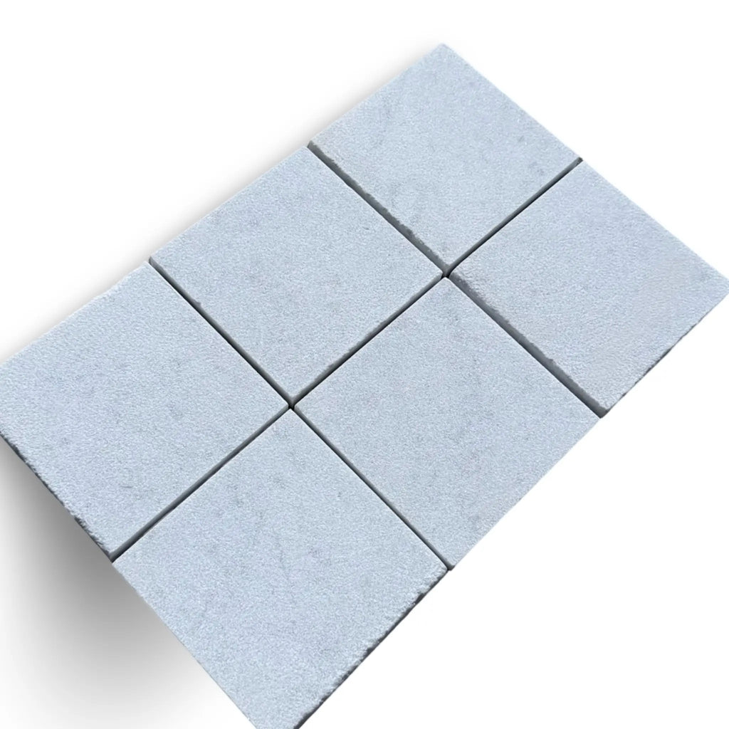 Six light blue square tiles from Calacatta Gold Marble Sand Blasted collection