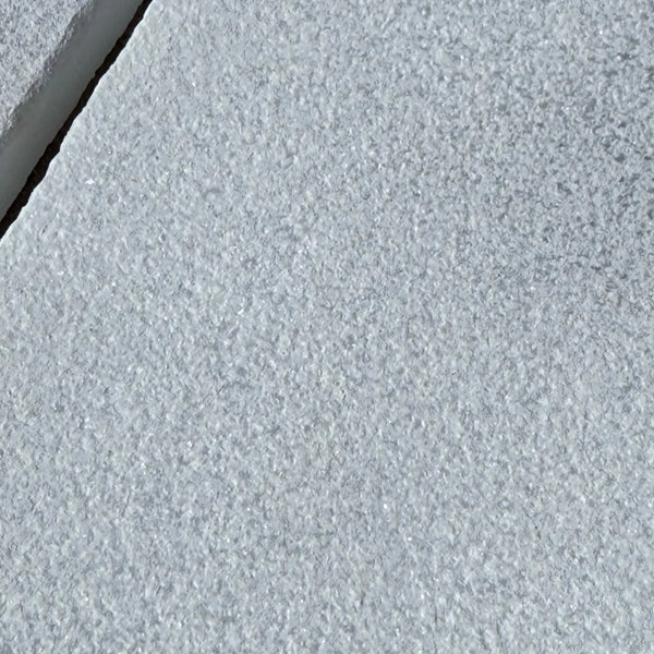 Textured gray stone surface of Calacatta Gold Marble in a sand blasted finish