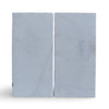 Two gray concrete blocks displayed with Calacatta Gold Marble in a sand blasted finish