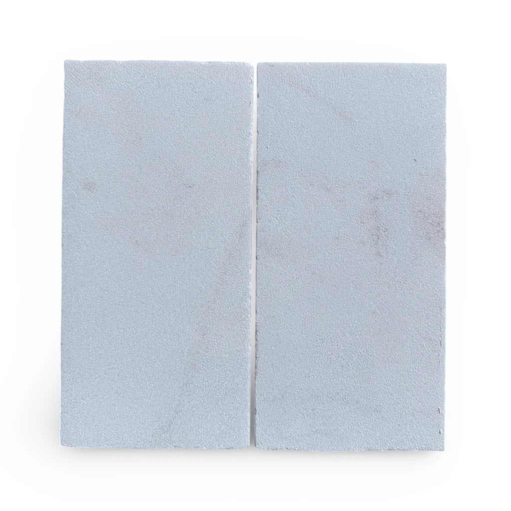 Two light blue rectangular blocks of Calacatta Gold Marble in a sand blasted finish