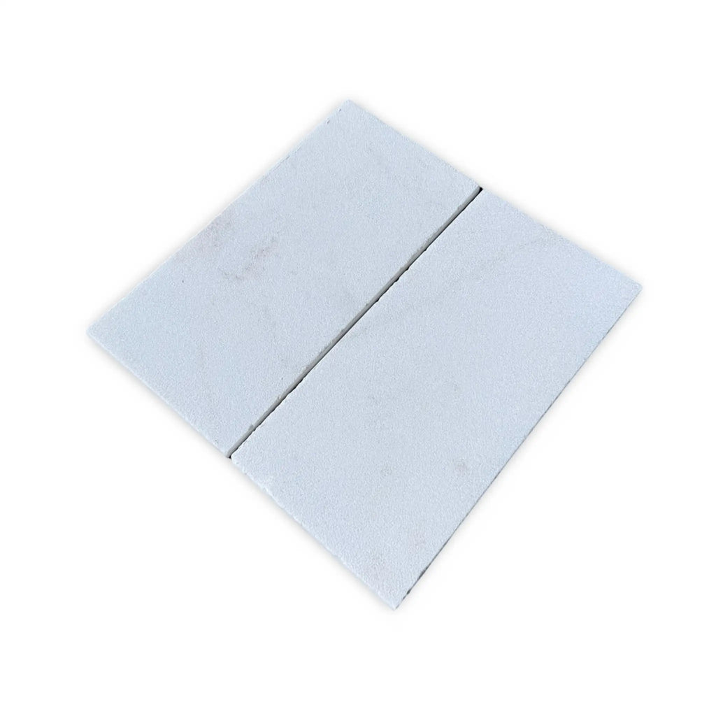 Two rectangular light-colored tiles of Calacatta Gold Marble in Sand Blasted finish