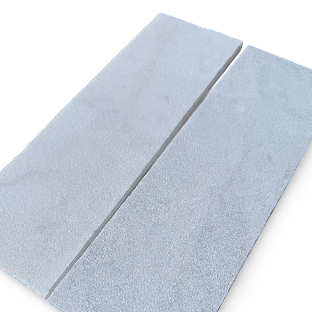 Two rectangular sharpening stones on Calacatta Gold Marble with a sand blasted finish