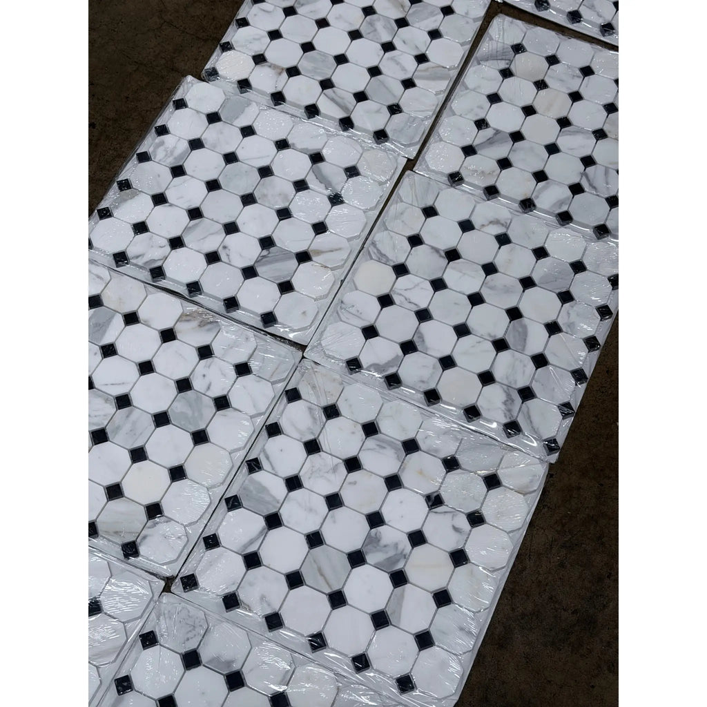 White marble calacatta gold octagon mosaic tile with black diamond accents wrapped in clear plastic packaging