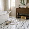 White freestanding bathtub with smooth glossy finish showcased on calacatta gold pinwheel blue-gray mosaic marble tile