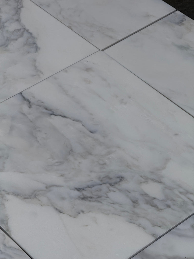 White marble-look floor tiles with grey veining from Calacatta Oliva Marble 12x24 collection