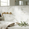 Gold-toned wall-mounted faucet with sleek modern design complementing calacatta verde royale marble 12x12 tile polished or honed