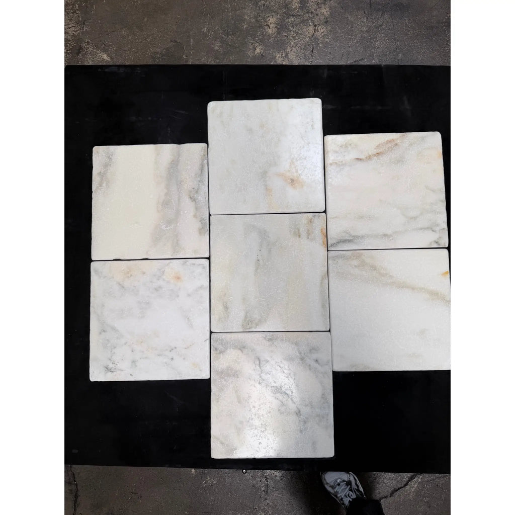 Calacatta verde royale marble 12x12 tile tumbled in white with subtle gray and beige veining arranged in a cross pattern