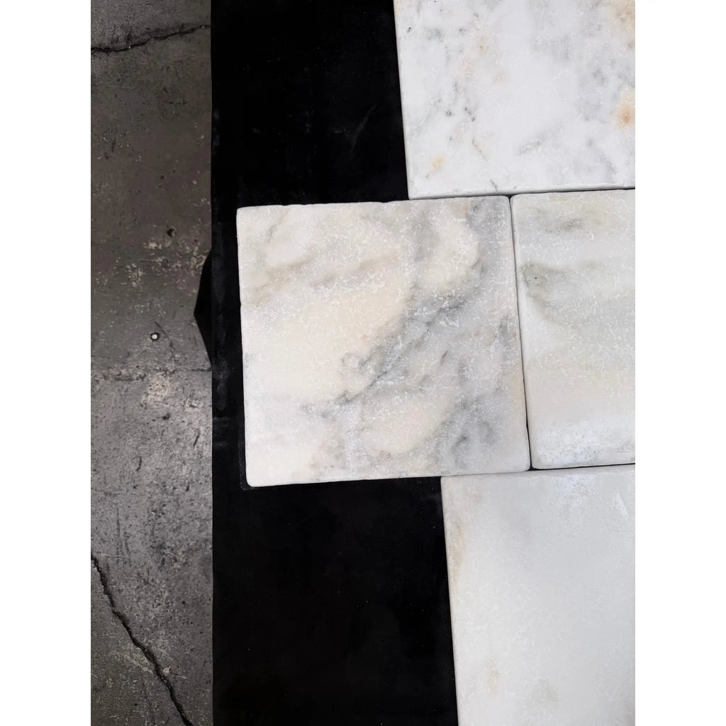 White marble 12x12 tumbled tile with subtle gray veining arranged in a modern pattern calacatta verde royale marble