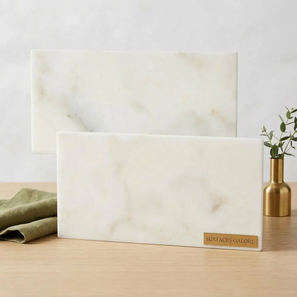 White marble serving boards with subtle gray veining and gold plaque branded surfaces galore for elegant serving