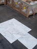 White marble floor tiles with grey veining from Calacatta Oliva Marble 12x24 collection