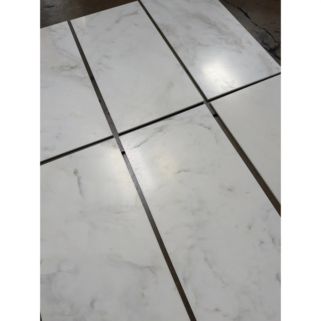 Calacatta Oliva marble 18x36 tile with white marble and black grout