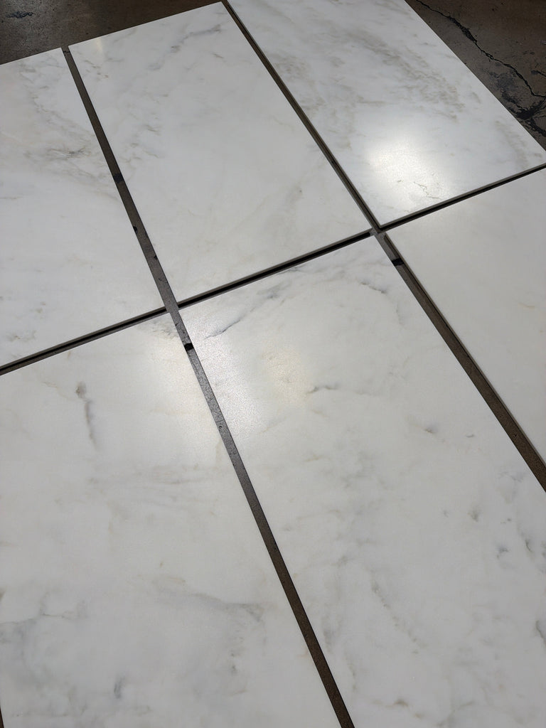 Calacatta Oliva marble 18x36 tile with white marble and black grout