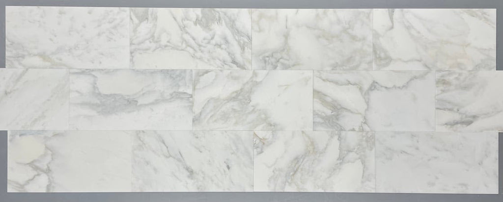 Calacatta Oliva Marble 18x36 tile with white marble subway style backsplash and grey veining