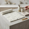 White marble calacatta verde royale 1x1 mosaic tile sheet with subtle veining laid on a concrete countertop