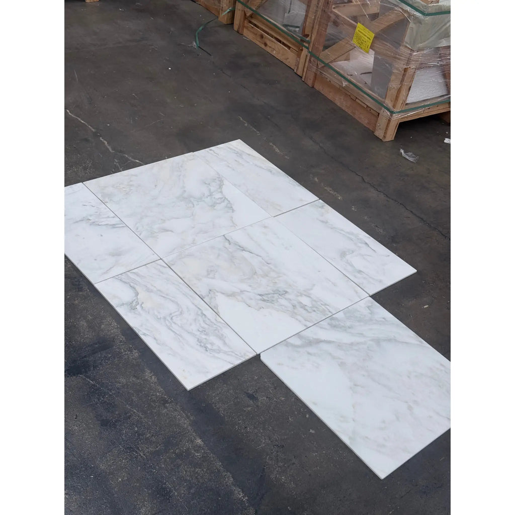 White marble-look porcelain tiles with gray veining in Calacatta Oliva Marble 24x24 style