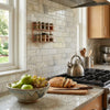 A copper spice rack with two tiers holding glass jars paired with calacatta verde royale marble 2x4 brick mosaic tile