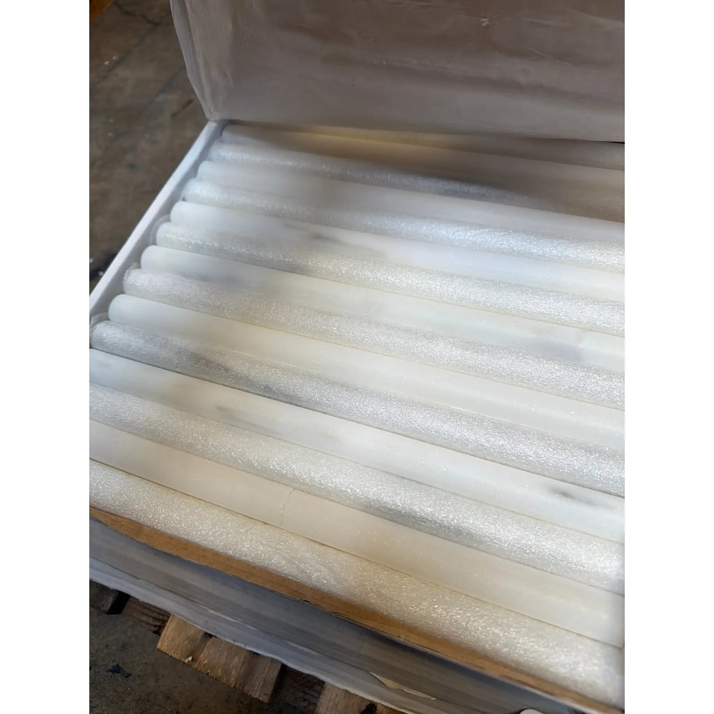 Calacatta Verde Royale marble bullnose liner molding in white rods arranged in foam box