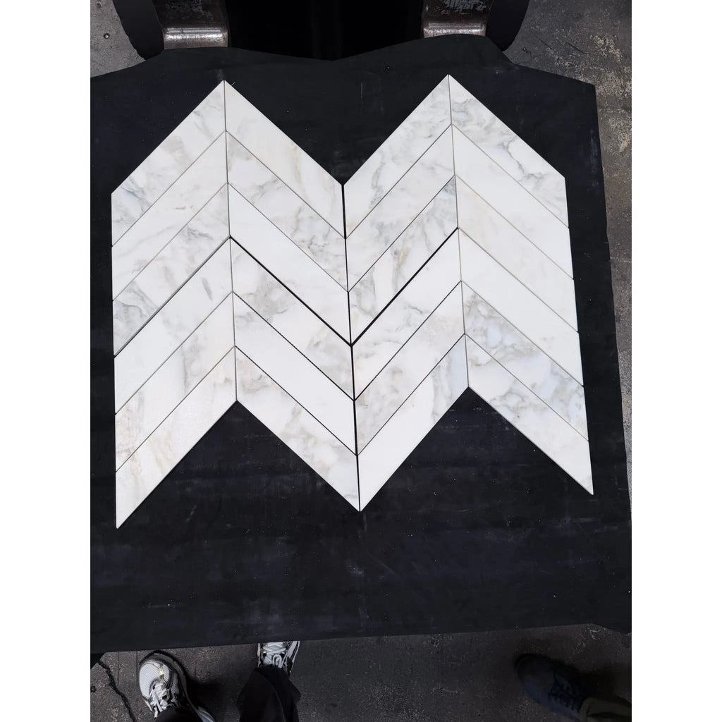White calacatta verde royale marble 3x12 polished-honed tiles arranged in a chevron mosaic pattern