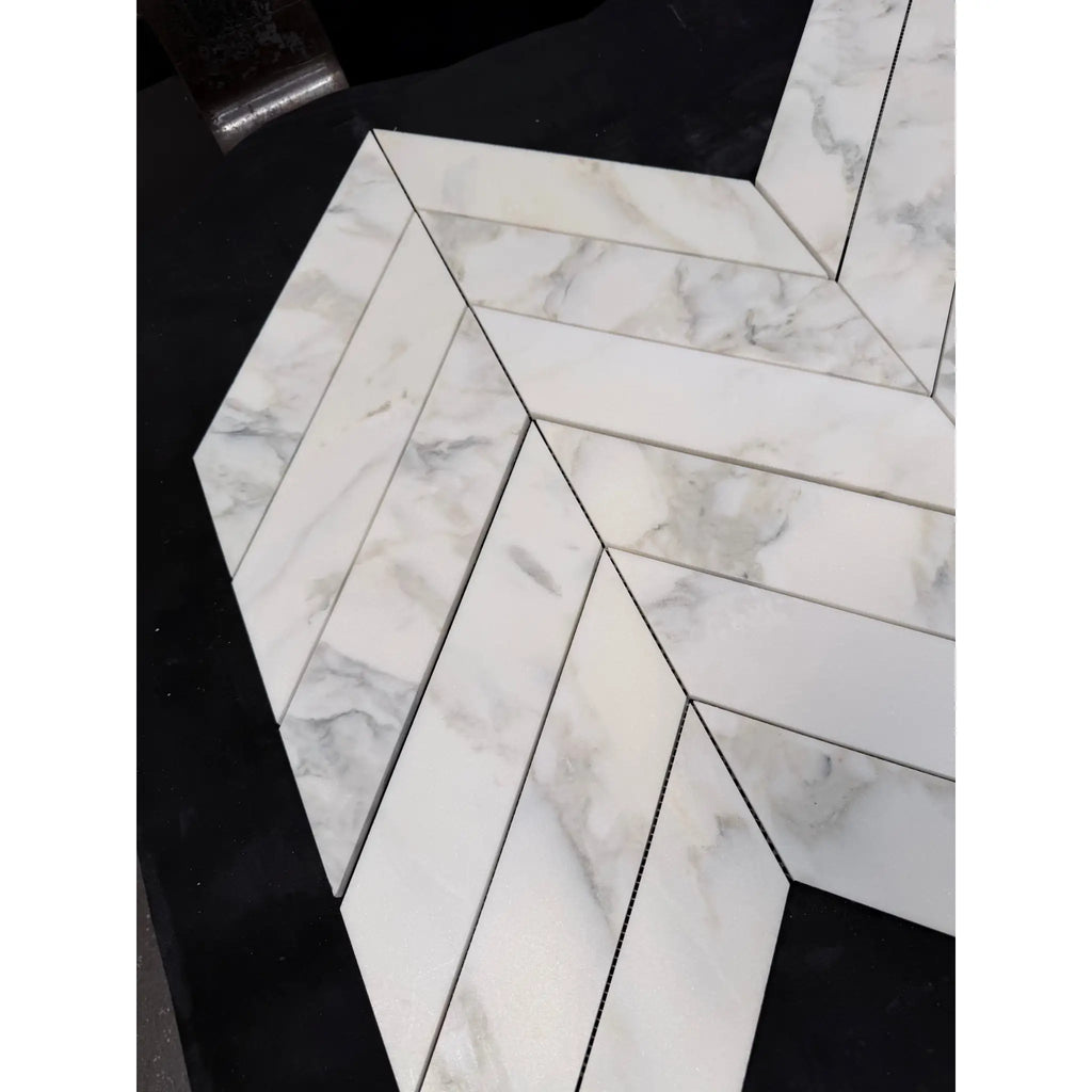 Calacatta Verde Royale marble 3x12 white tiles with gray veining arranged in a polished-honed chevron mosaic pattern