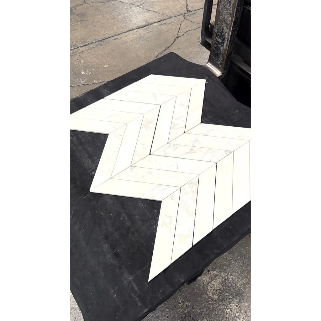 Calacatta verde royale marble 3x12 polished-honed white marble tiles arranged in a herringbone chevron mosaic pattern