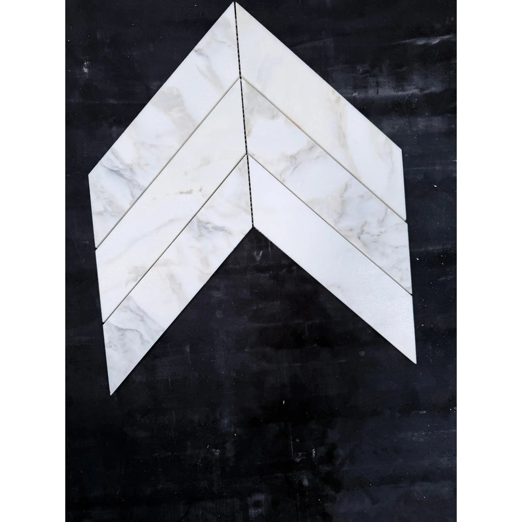 White marble-effect calacatta verde royale 3x12 polished-honed tiles arranged in a chevron mosaic pattern