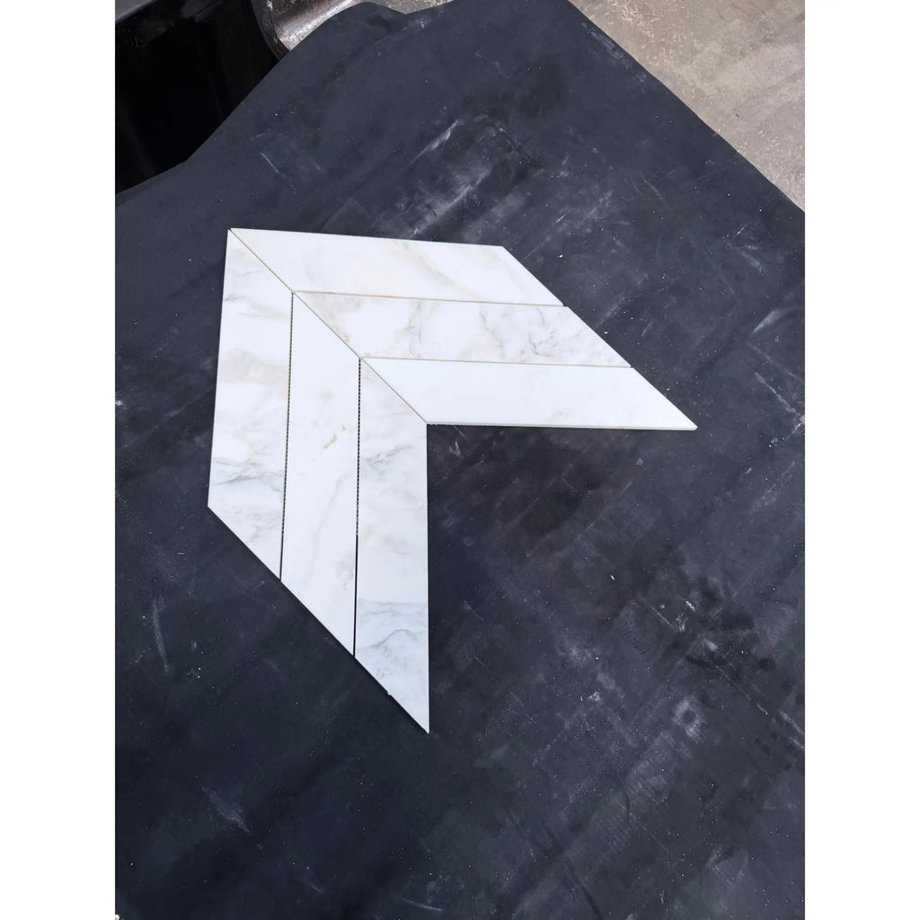 White marble-effect calacatta verde royale marble 3x12 polished-honed tiles arranged in a chevron mosaic pattern